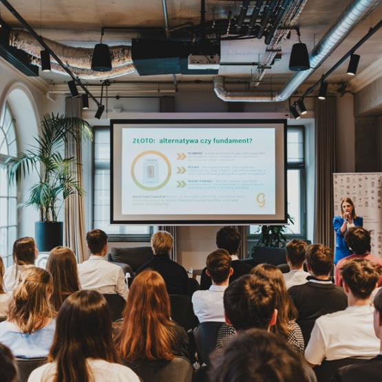 zdjęcie zrobione z tyłu sali przedstawiające studentów słuchających panelu