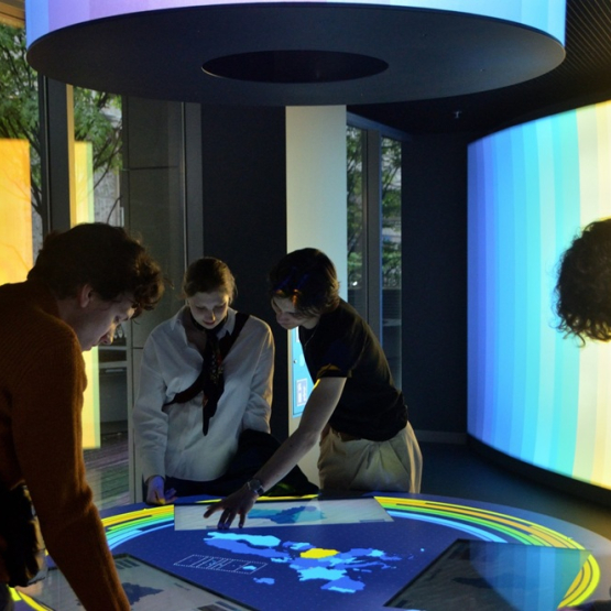 trzy osoby nad podświetloną mapą