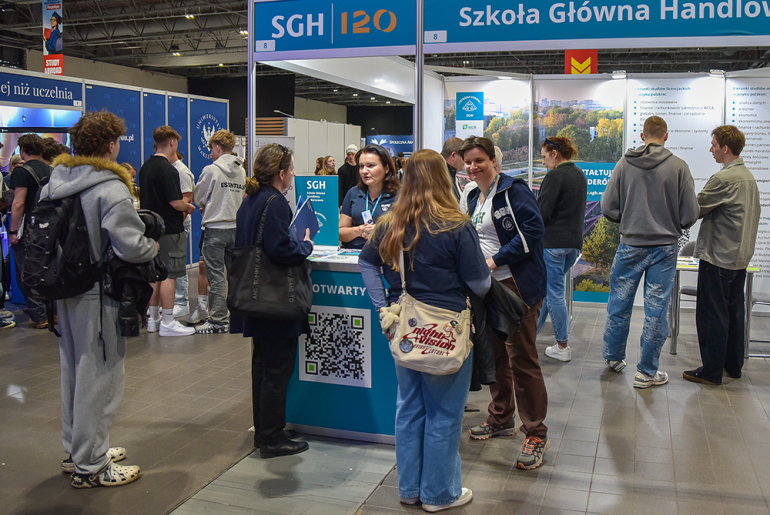 dużo ludzi przy stoisku targowym