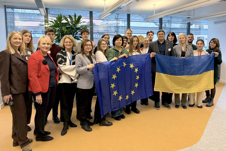 Grupa ludzi trzymająca flagi UE i Ukrainy