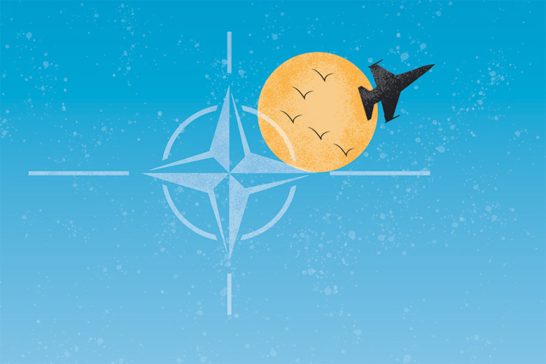 grafika przedstawiająca symbol NATO, słońce oraz samolot odrzutowy, bojowy. Na tle słońca 5 ptaków lecących w kluczu