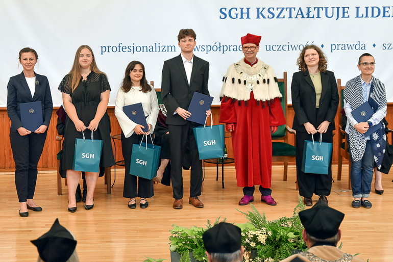 Sześć osób z nagrodami w towarzystwie Rektora SGH w oficjalnym stroju