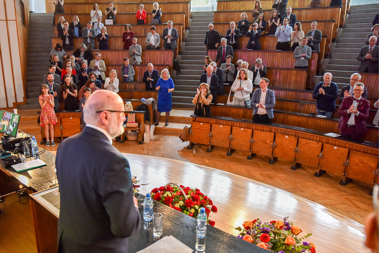 mężczyzna stojący przed uczestnikami konferencji w auli spadochronowej