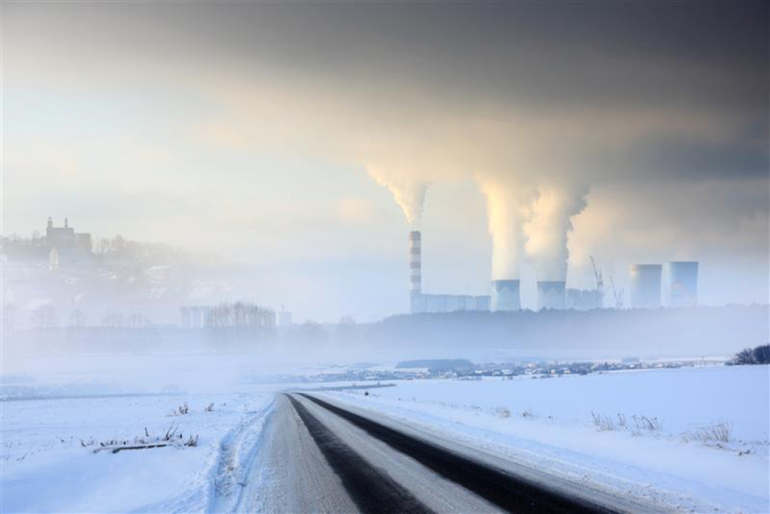 zaśnieżone pole, w oddali dymiące kominy