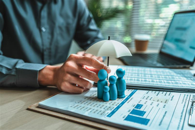 otwarte zeszyty, ludziki i dłoń człowieka trzymająca mały parasol