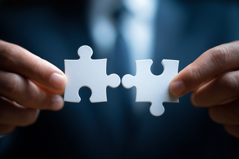 dłonie łączące elementy puzzli