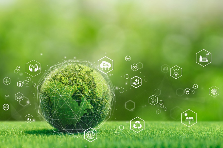 grafika przedstawiająca kulę ziemską z trawy, tocząca sie po trawie; wokół niej symbole Co2, odnawialnej energii etc.