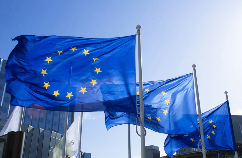 trzy powiewające flagi unijne