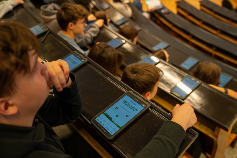 młodzi rozwiązują test wiedzy na jednej z uczelnianych auli