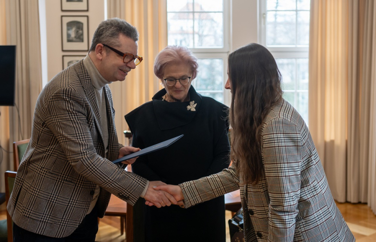 mężczyzna składa gratulacje młodej kobiecie, po środku druga kobieta