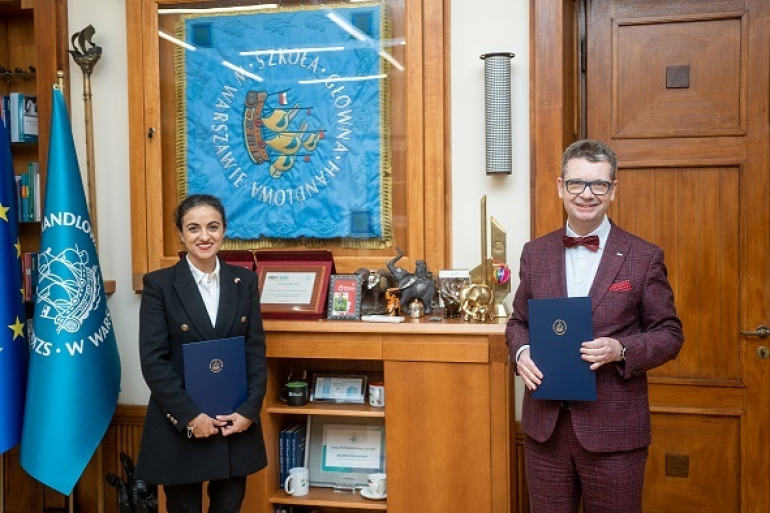 dwoje ludzi stoi w gabinecie, trzymając teczki z dokumentami