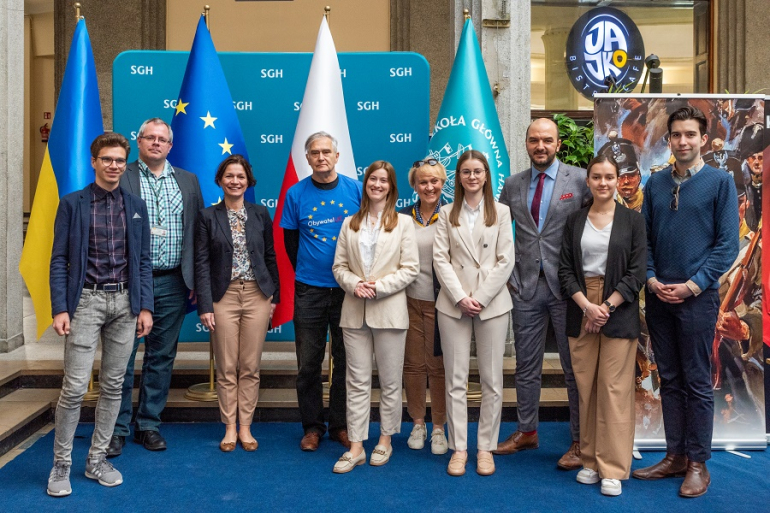 grupa osób na tle flag Polski, UE, Ukrainy i SGH