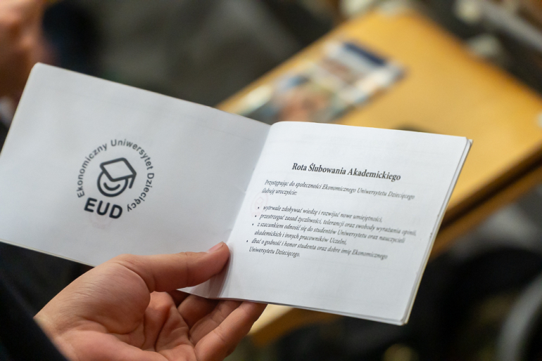 zdjęcie trzymanej w dłoni książeczki z tekstem ślubowania