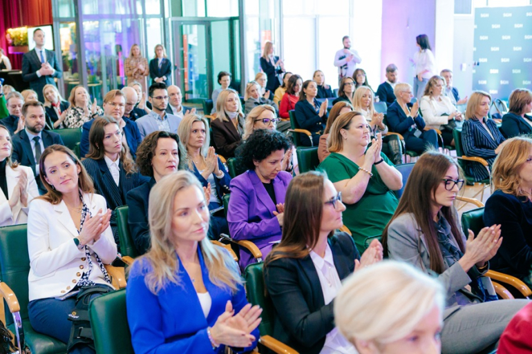 kilkadziesiąt osób siedzi na sali 