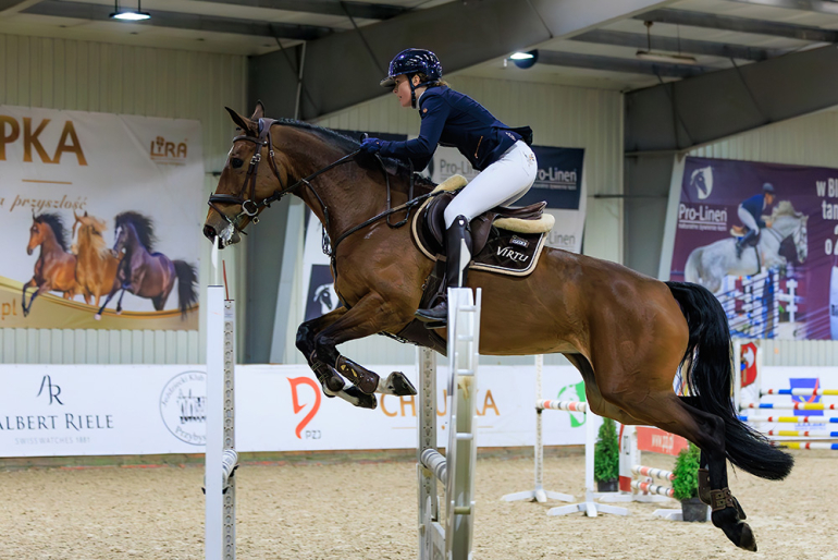kobieta na koniu skaczącym przez przeszkody