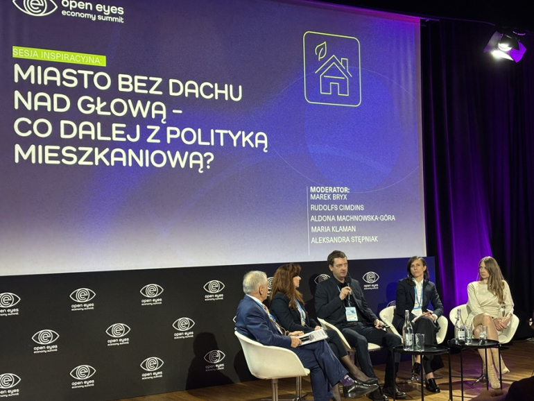 zdjęcie z panelu - piec osób debatuje na scenie