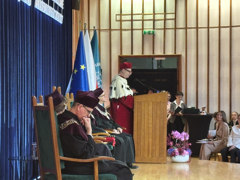 kilka osób siedzi na scenie podczas inauguracji roku akademickiego