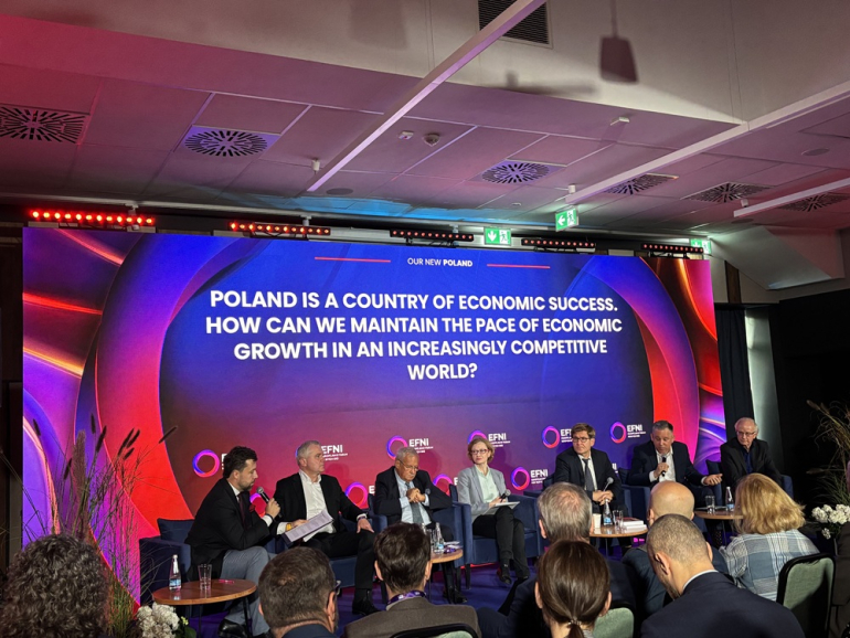 na zdjęciu kilka osób siedzących na panelu