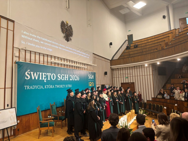 doktorzy i doktorzy habilitowani podrzucają w górę birety podczas uroczystości na uczelni