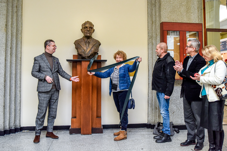 Rektor wraz z córką prof. Grodka odsłaniają popiersie profesora; obok zaproszeni goście