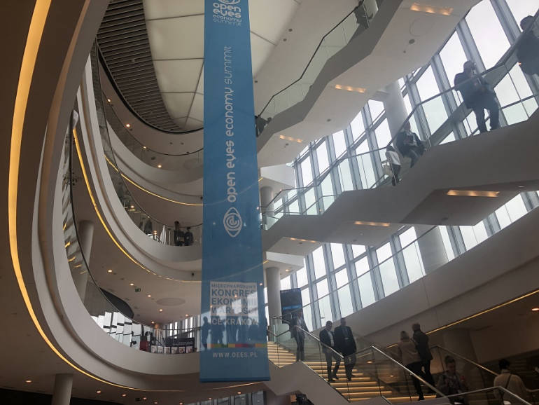 wiszący banner Open Eyes Economy Summit 2023 w hallu obiektu konferencyjnego