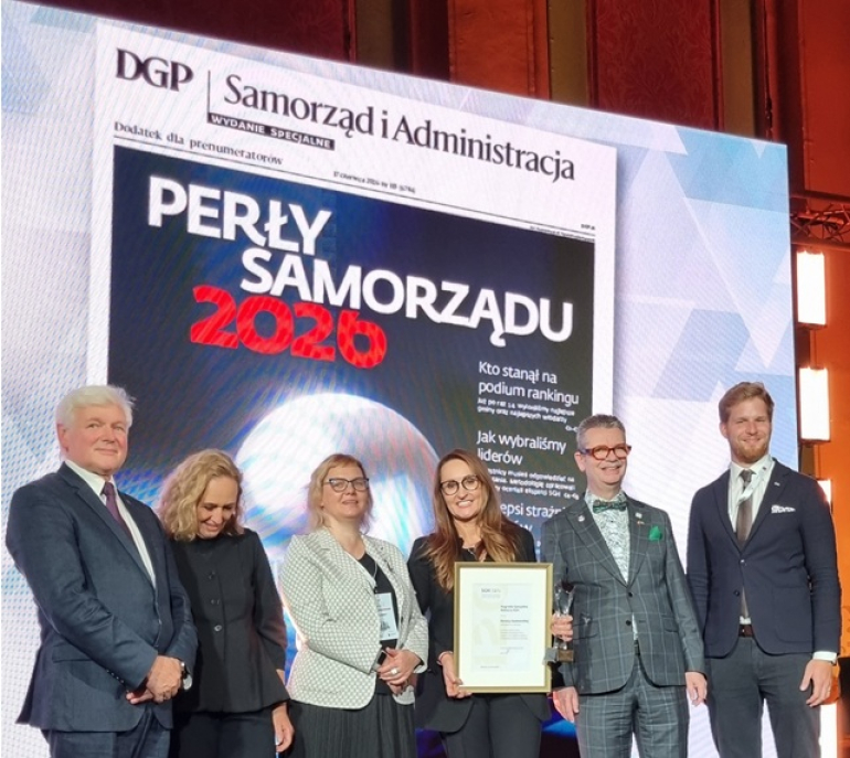 kilka osób na scenie, w tle wyświetlany napis