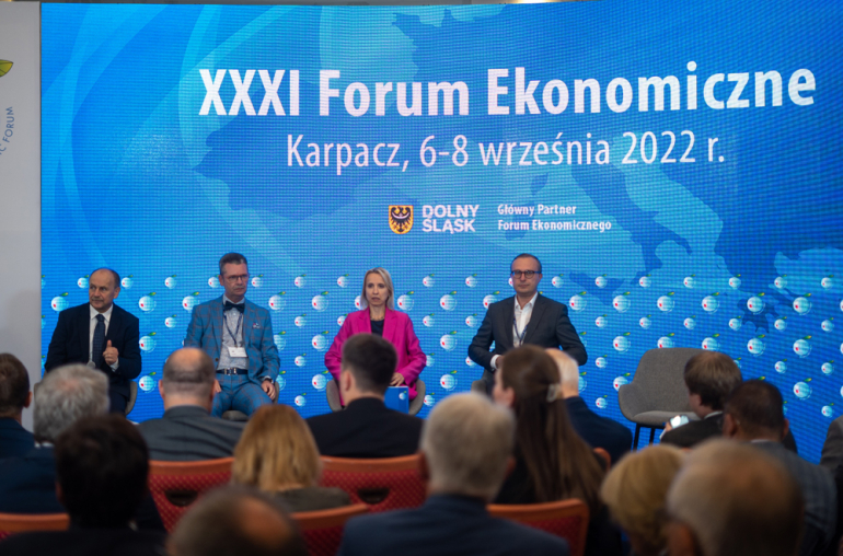 cztery osoby siedzą na scenie; w tle napis na ściance XXXI Forum ekonomiczne, Karpacz 6-8 wrzesnia 2022