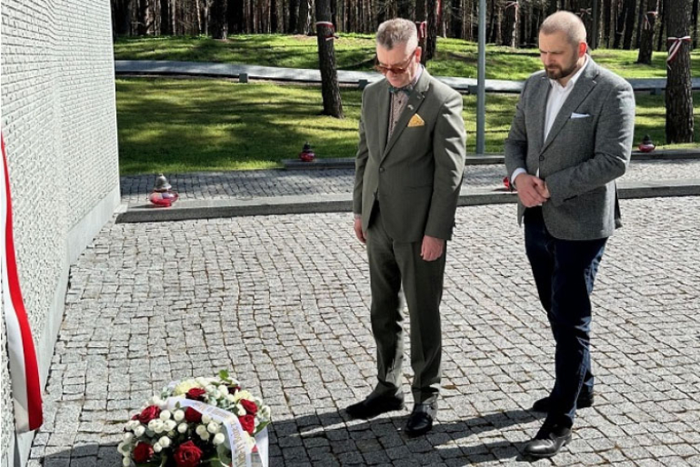 dwóch mężczyzn składa wiązankę