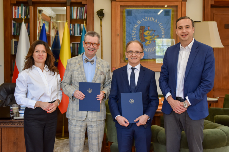 cztery osoby stoją w gabinecie po podpisaniu porozumienia