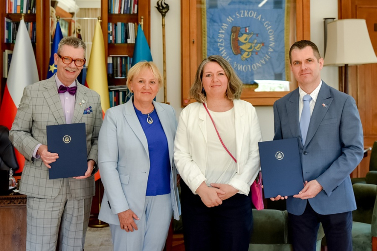 dwie kobiety i dwóch mężczyzn w gabinecie po podpisaniu porozumienia