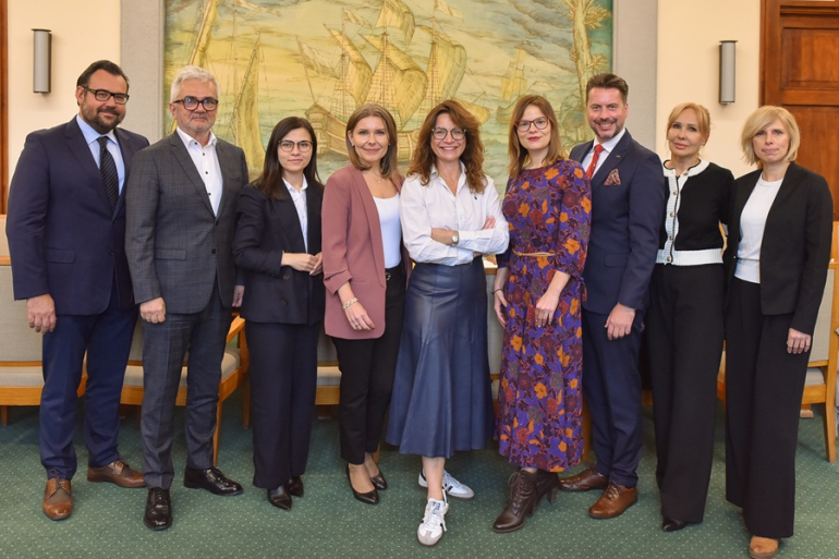 grupa osób pozuje do zdjęcia w sali uczelni