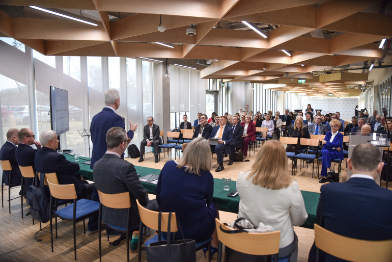 zdjecie zrobione z perspektywy stołu prezydialnego - cała sala pełna ludzi na spotkaniu