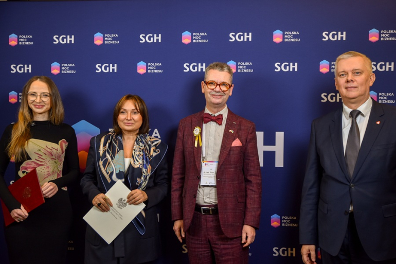 dwóch mężczyzn i dwie kobiety pozują do zdjęcia na tle ścianki