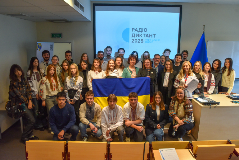 grupa osób pozuje ze ukraińską flagą