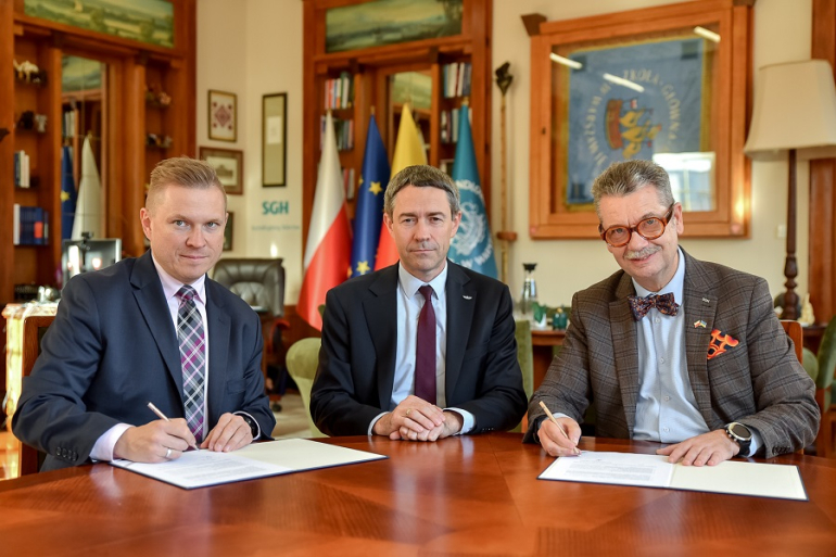 trzech mężczyzn podpisuje dokumenty