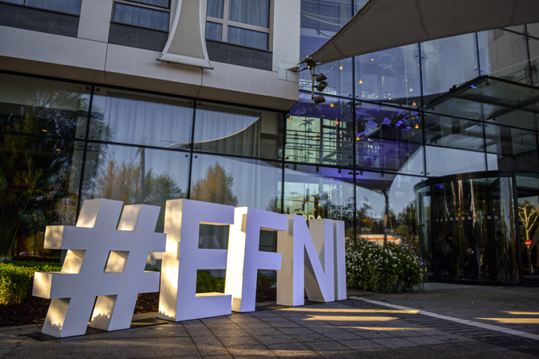 duże białe litery ułożone na ziemi układające się w napis: #EFNI