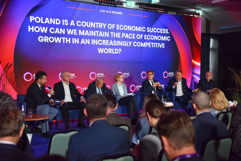 na zdjęciu kilka osób siedzących na panelu