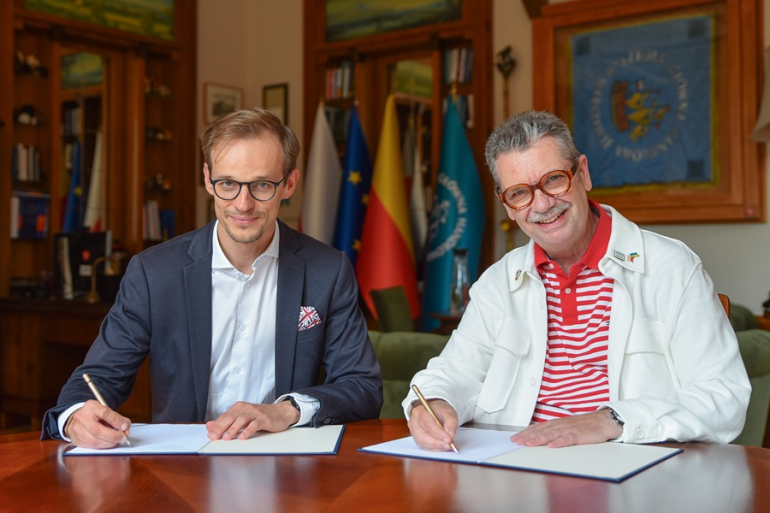 dwóch mężczyzn podpisuje umowę