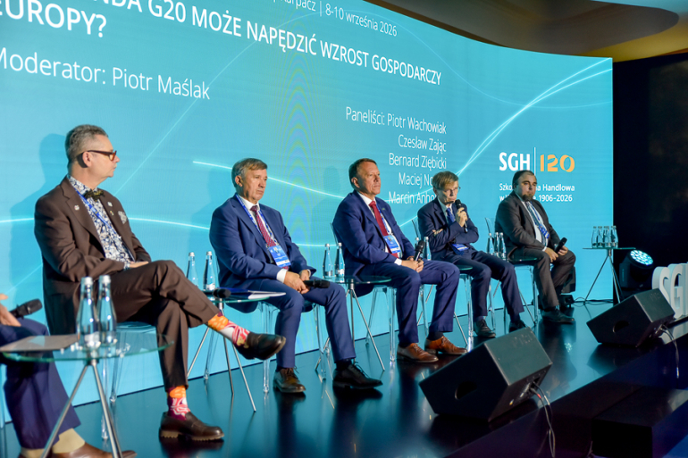 kilka osób rozmawia na scenie na panelu