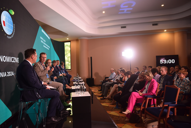 sala wypełniona publicznością i prowadzący - panel 