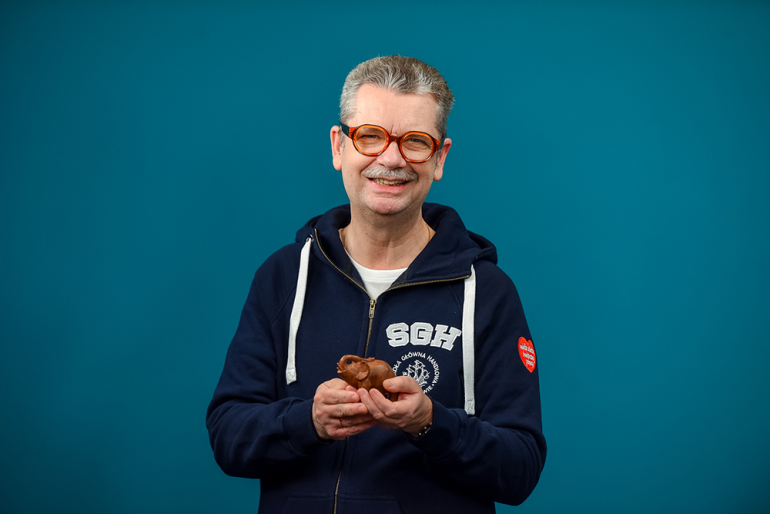 mężczyzna w bluzie SGH z logo WOŚP trzymający słonia