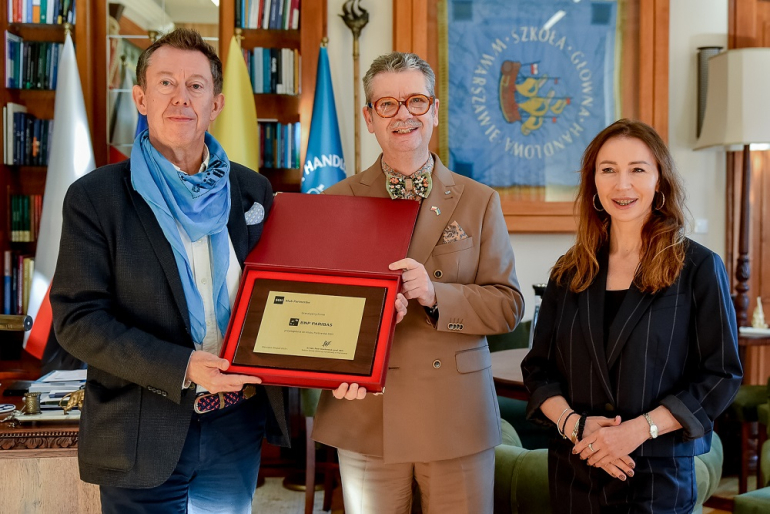 na zdjęciu trzy osoby trzymające złota tabliczkę