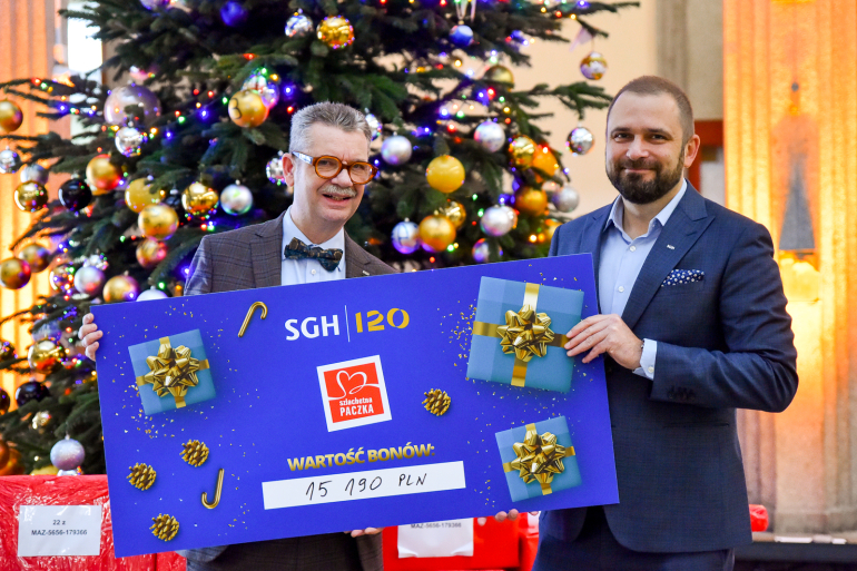 dwóch mężczyzn trzyma duży czek 