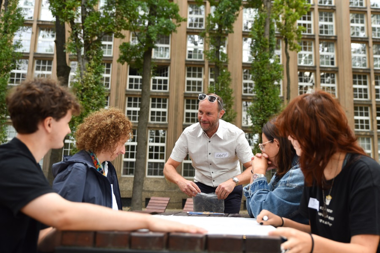 profesor i studenci na warsztatach na zewnątrz budynku