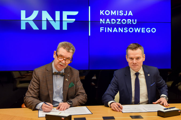 dwóch mężczyzn podpisuje dokument