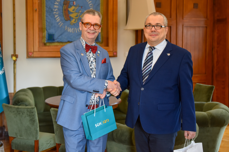 dwóch mężczyzn podaje sobie ręce w gabinecie