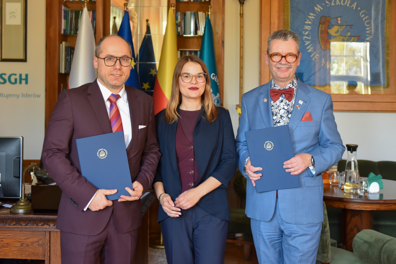 trzy osoby w gabinecie po podpisaniu porozumienia