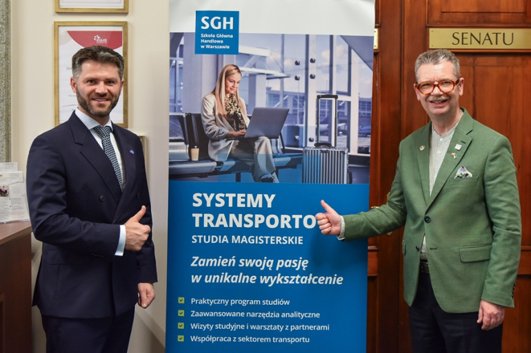 dwóch mężczyzn stoi przy rollupie