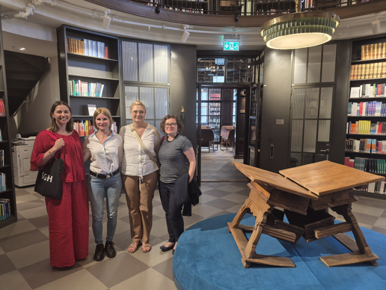 zdjęcie czterech kobiet na uczelni, w środku biblioteki