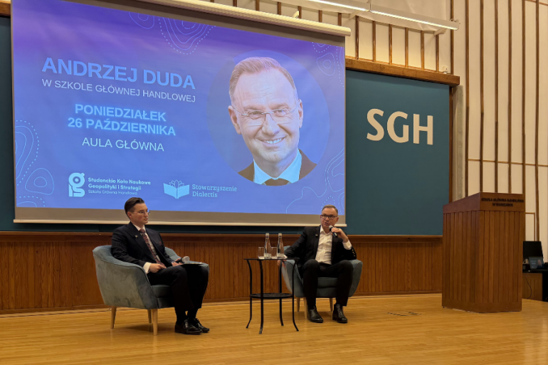 dwóch mężczyzn rozmawia ze sobą na scenie, z tyłu wyświetlony ekran